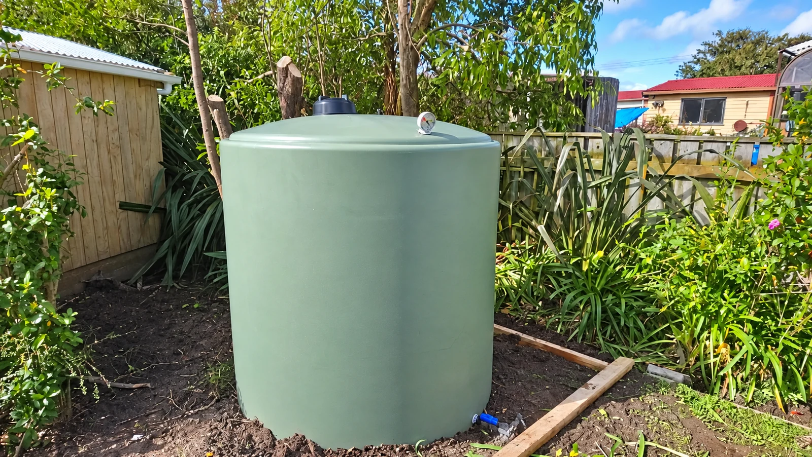 Green water tank installed in a residential garden
