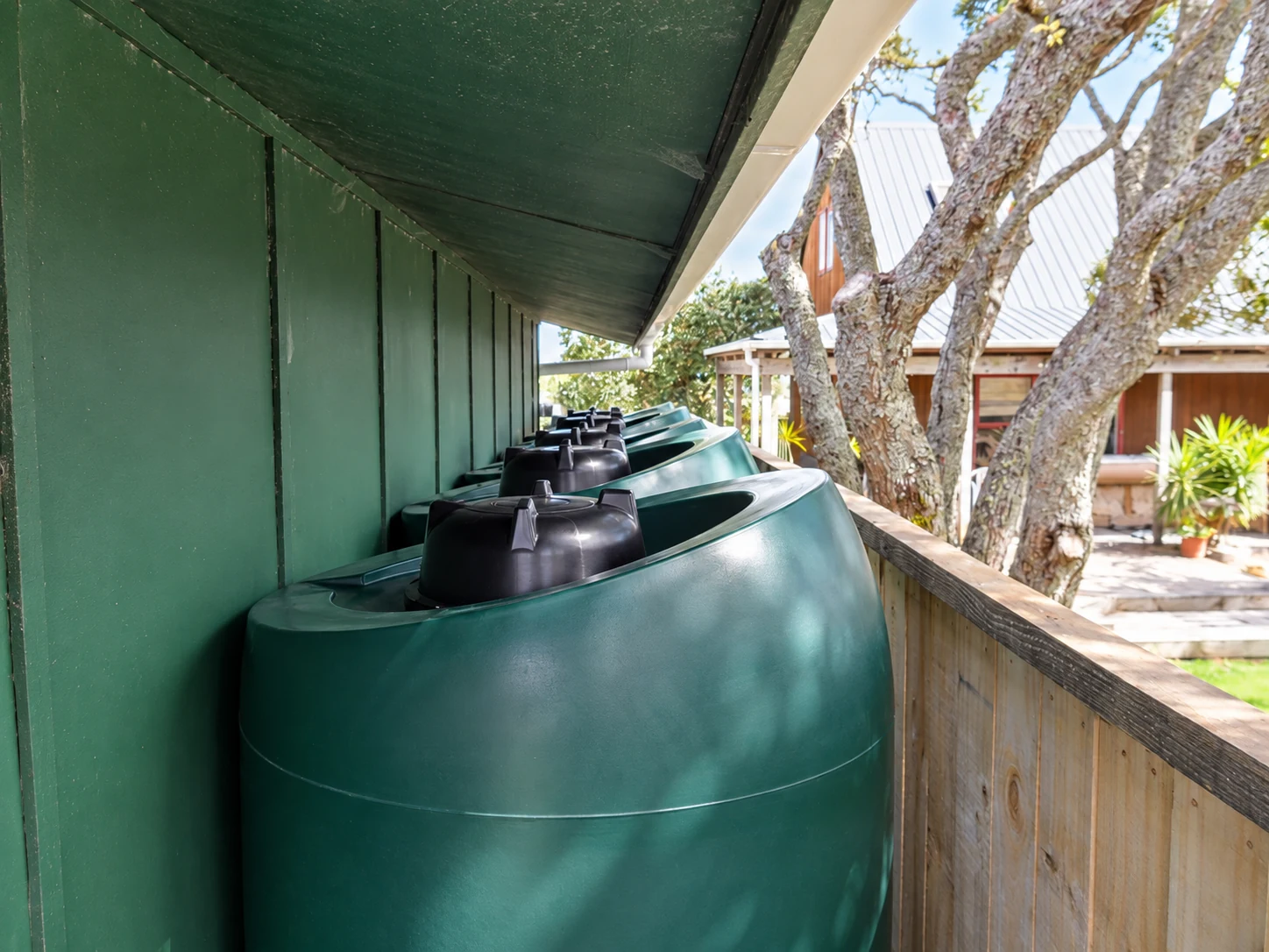 Row of green tanks installed beneath house eaves