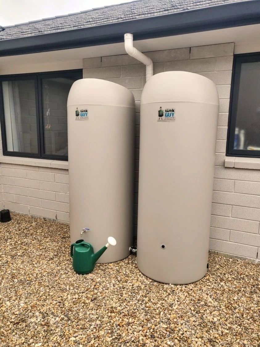 Two slimline rainwater tanks connected beside a home
