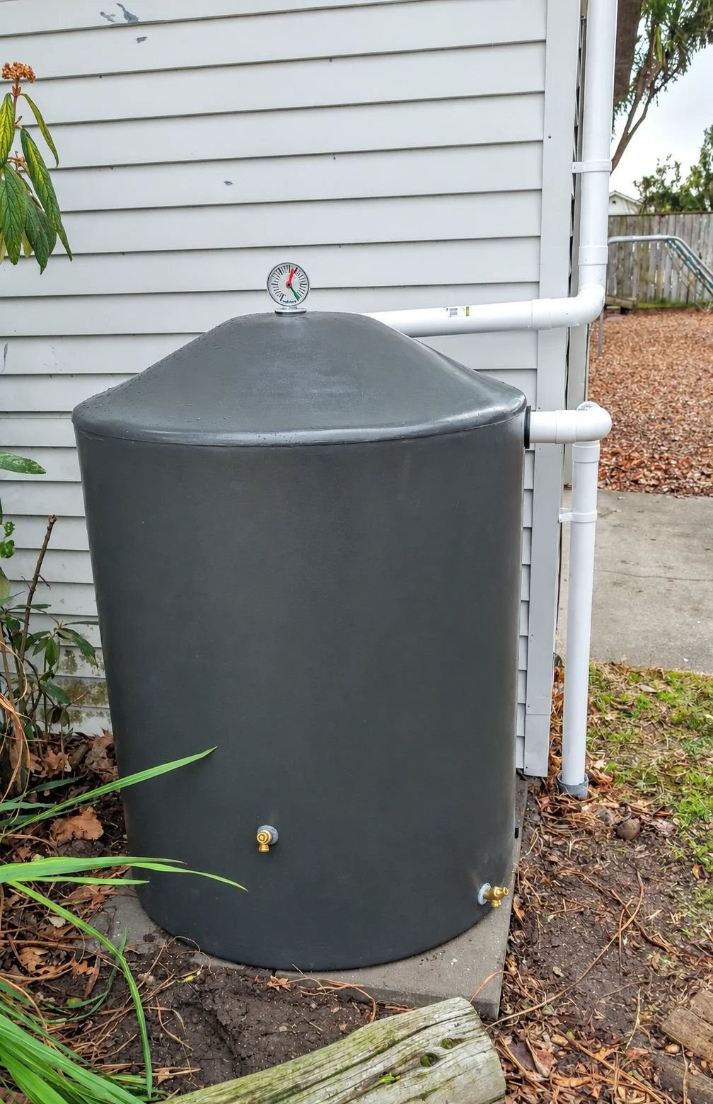 Water tank with gauge and rainwater collection pipework